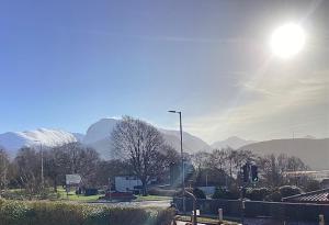 Eine Straßenlaterne auf einer Straße mit Bergen im Hintergrund in der Unterkunft Uachan in Corpach