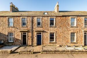 an old brick building with a blue door at Dylsford - Elie in Elie