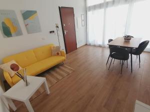 a living room with a yellow couch and a table at La Dimora del Cuore - U1598 in Olbia +24 photos