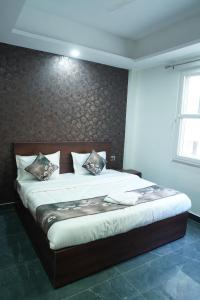 a bedroom with a large bed with a wooden headboard at Rudra Homestay - Rishikesh in Rishīkesh