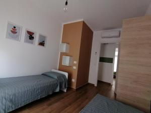a bedroom with a bed and a wall with pictures at La Dimora del Cuore - U1598 in Olbia