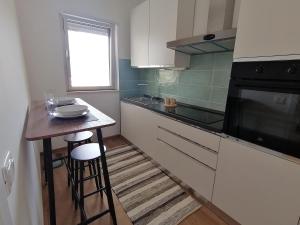 a kitchen with a counter and a table with stools at La Dimora del Cuore - U1598 in Olbia