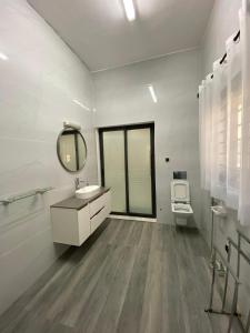 a bathroom with a sink and a mirror and a toilet at Le grand luxe in Cotonou +24 photos