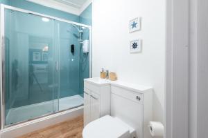 a bathroom with a glass shower and a toilet at Glan Neigr Apart-Hotel by Guestz in Rhosneigr +170 photos