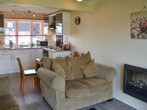 a living room with a couch and a fireplace at Puffin Cottage in Wroxham