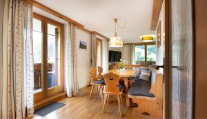 a dining room and living room with a table and chairs at Gästehaus Felder in Hirschegg