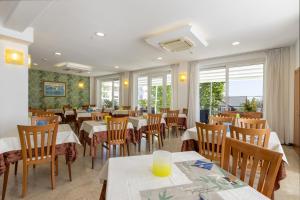 a restaurant with tables and chairs and windows at Hotel Bridge in Rimini
