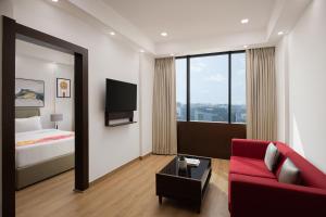 a hotel room with a red couch and a bed at Ginger Gurugram, Sector 1 in Gurgaon