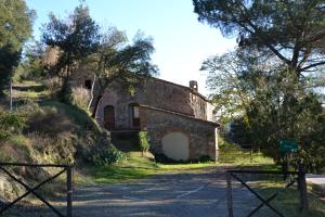 an old stone building on a hill next to a road at LA GRANCIA DEL SANTO in Monticiano