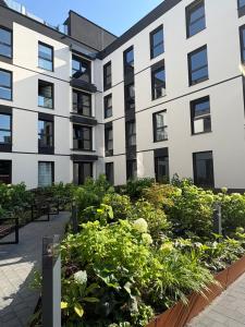 an apartment building with a garden of plants at Praga Studio Apartments in Warsaw