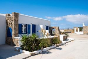 a blue and white house with plants in front of it at Katerina View in Mikonos