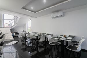 a dining room with tables and white chairs at The Rock Hostel in Ponta Delgada