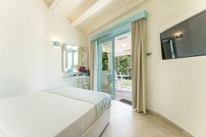 a bedroom with a bed and a flat screen tv at Oasi Blu Sardinia in Santa Margherita di Pula