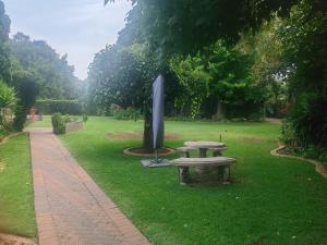 a park with a bench and a monument in the grass at Kahunaz in Vereeniging