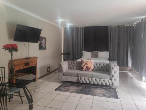 a living room with a couch in front of a bed at Kahunaz in Vereeniging