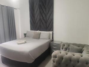 a bed and a chair in a bedroom at Kahunaz in Vereeniging +17 photos
