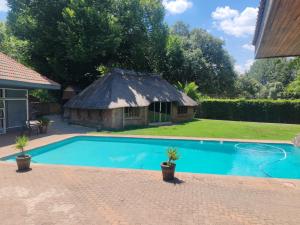 a small swimming pool with a thatch roof at Kahunaz in Vereeniging