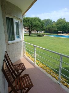 a porch with a bench and a fence and a field at Parkofir in Fão
