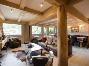 a living room with a couch and a table at Chalet 4★, 11 pers, 6 ch, terrasse sud, animaux admis - FR-1-304-21 in La Clusaz