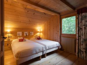 a bedroom with two beds in a log cabin at Chalet 4★, 11 pers, 6 ch, terrasse sud, animaux admis - FR-1-304-21 in La Clusaz