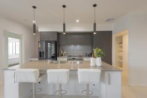 a kitchen with a large island with white bar stools at Shipwreck Park Villas in Westfield