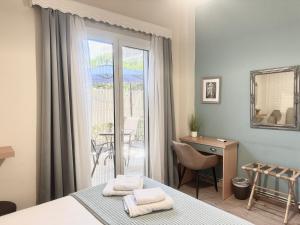 a bedroom with a bed and a desk and a balcony at Luxury seafront house nearby Delphi in Kírra