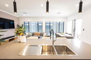 a kitchen with a sink and a living room at Shipwreck Park Villas in Westfield