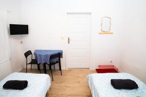 a room with two beds and a table and a chair at Hostel Jamnik in Psary