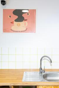 a kitchen with a sink and a picture on the wall at Hostel Jamnik in Psary