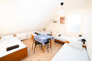 a room with two beds and a table and chairs at Hostel Jamnik in Psary