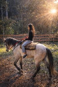 a woman riding on the back of a horse at Chalé Mi casa Su casa in Itamonte