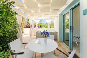 a dining room with a white table and chairs at Oasi Blu Sardinia in Santa Margherita di Pula