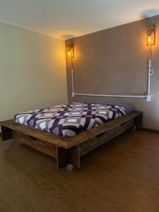 a bed in the corner of a room at Chalé Mi casa Su casa in Itamonte