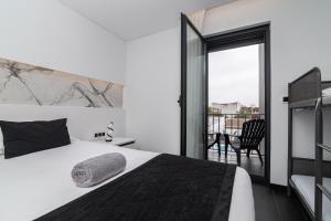a bedroom with a bed and a balcony at The Rock Hostel in Ponta Delgada +58 photos
