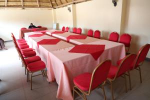 a conference room with a long table and red chairs at Simbego Cottages Lira in Lira