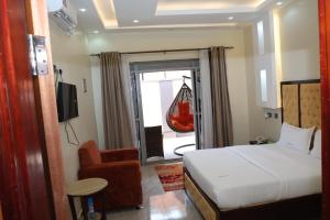 a bedroom with a bed and a chair and a swing at Simbego Cottages Lira in Lira +84 photos
