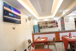 a restaurant with tables and chairs and a bar at Simbego Cottages Lira in Lira