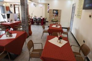 a dining room with red tables and chairs at Simbego Cottages Lira in Lira