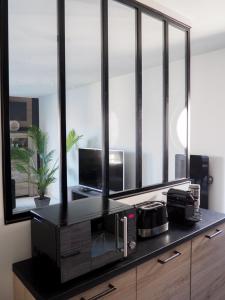 a kitchen with a counter with a microwave and a mirror at Appartement spacieux - Vue notre dame de la garde - Terrasse - Wifi in Marseille +10 photos