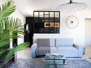 a living room with a blue couch and a glass table at Appartement spacieux - Vue notre dame de la garde - Terrasse - Wifi in Marseille