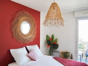 a bedroom with a red wall with a bed and a mirror at Appartement spacieux - Vue notre dame de la garde - Terrasse - Wifi in Marseille