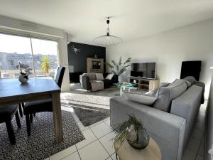 a living room with a couch and a table at Appartement spacieux - Vue notre dame de la garde - Terrasse - Wifi in Marseille