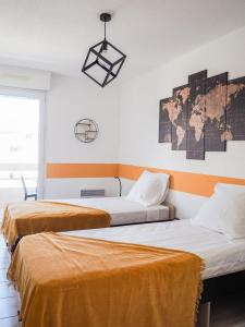 a room with two beds and a map on the wall at Appartement spacieux - Vue notre dame de la garde - Terrasse - Wifi in Marseille