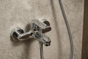 a shower faucet with a hose in a bathroom at Louladakis Apartments in Kolymvari