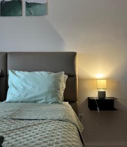 a bedroom with a bed with a lamp next to it at Apartman Panorama in Temerin