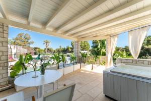 an outdoor patio with a table and a bathtub at Oasi Blu Sardinia in Santa Margherita di Pula
