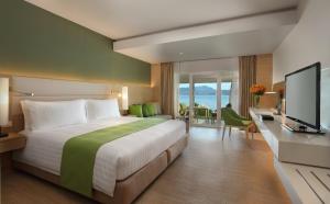 a hotel room with a large bed and a television at Amari Phuket in Patong Beach +106 photos