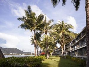 a row of palm trees in front of a building at Amari Phuket in Patong Beach