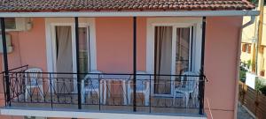 a balcony with chairs and tables on a building at Apartments Elena in Kavos +6 photos