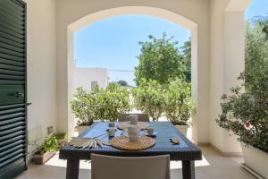 a blue table and chairs on a patio with an archway at ostuni In suite in Ostuni